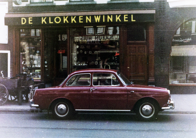 856004 Afbeelding van een geparkeerde auto voor De Klokkenwinkel van J. Kool (Voorstraat 15) te Utrecht.